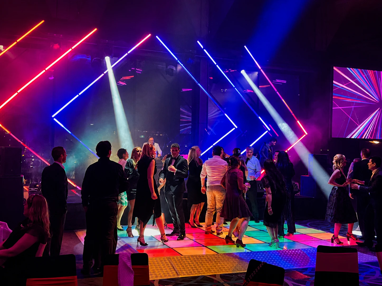 Guests dancing on a multicolour LED dance floor at an illuminated event
